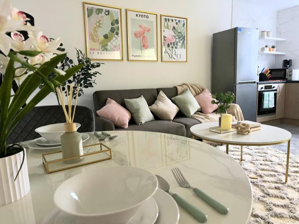 ein Wohnzimmer mit Tisch und Couch in der Unterkunft Artistic 2 bed flat in Bolton City Centre in Bolton