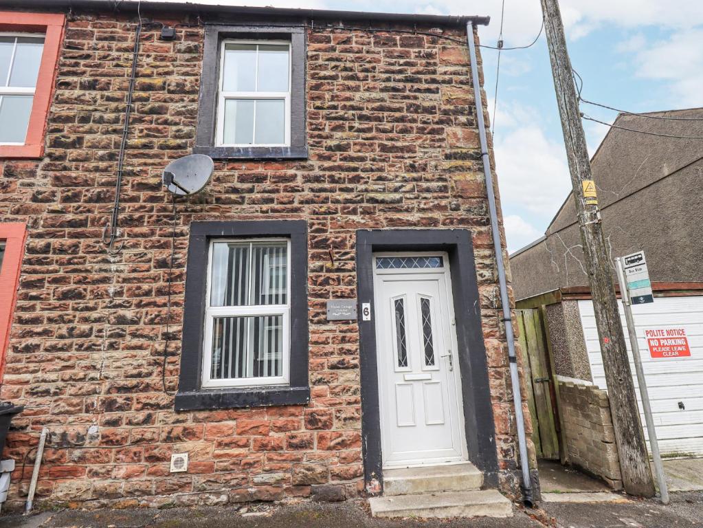 an old brick building with a white door at Violey Cottage in Maryport