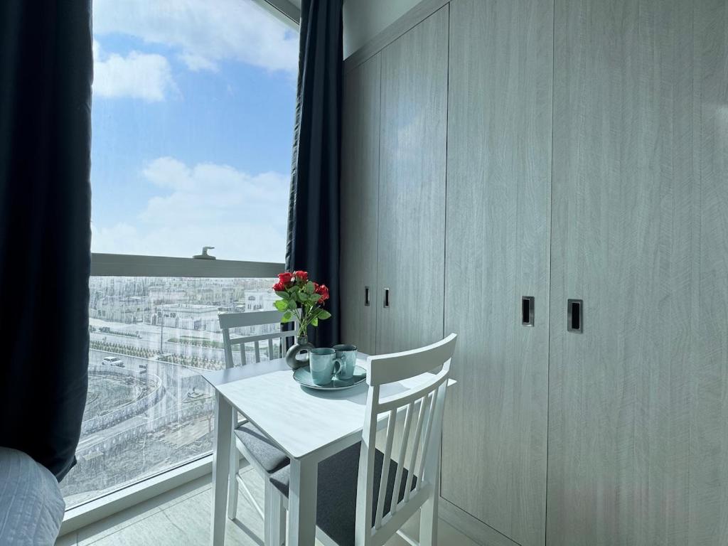 un tavolo bianco e sedie in una stanza con una finestra di Luxury Private Apartment-BEST PRICE a Abu Dhabi