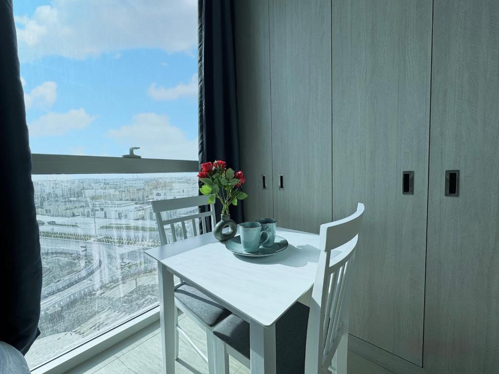 un tavolo bianco e sedie in una stanza con una finestra di Luxury Private Apartment-BEST PRICE a Abu Dhabi
