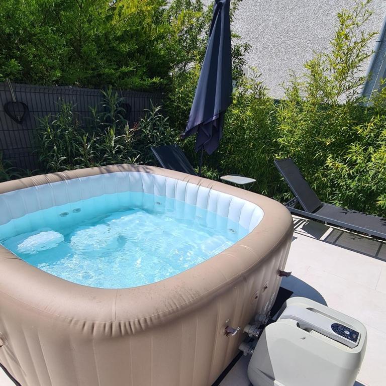 - un bain à remous dans la cour avec un parasol dans l'établissement La Dolce Vita, à Ambérieu-en-Bugey