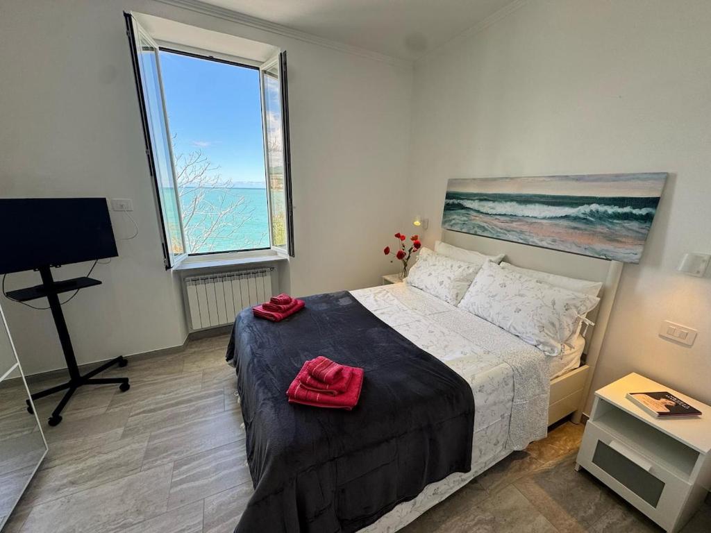 a bedroom with a bed and a large window at Splendida Casa vista mare per 4 persone di fronte alle spiagge di Bussana in Bussana Nuova