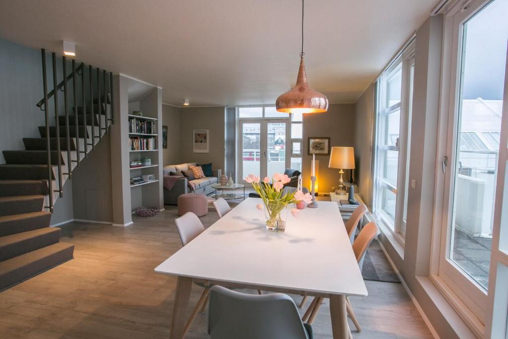 レイキャビクにあるPenthouse Downtown with Free Parkingのテーブルと椅子のあるダイニングルームとリビングルーム