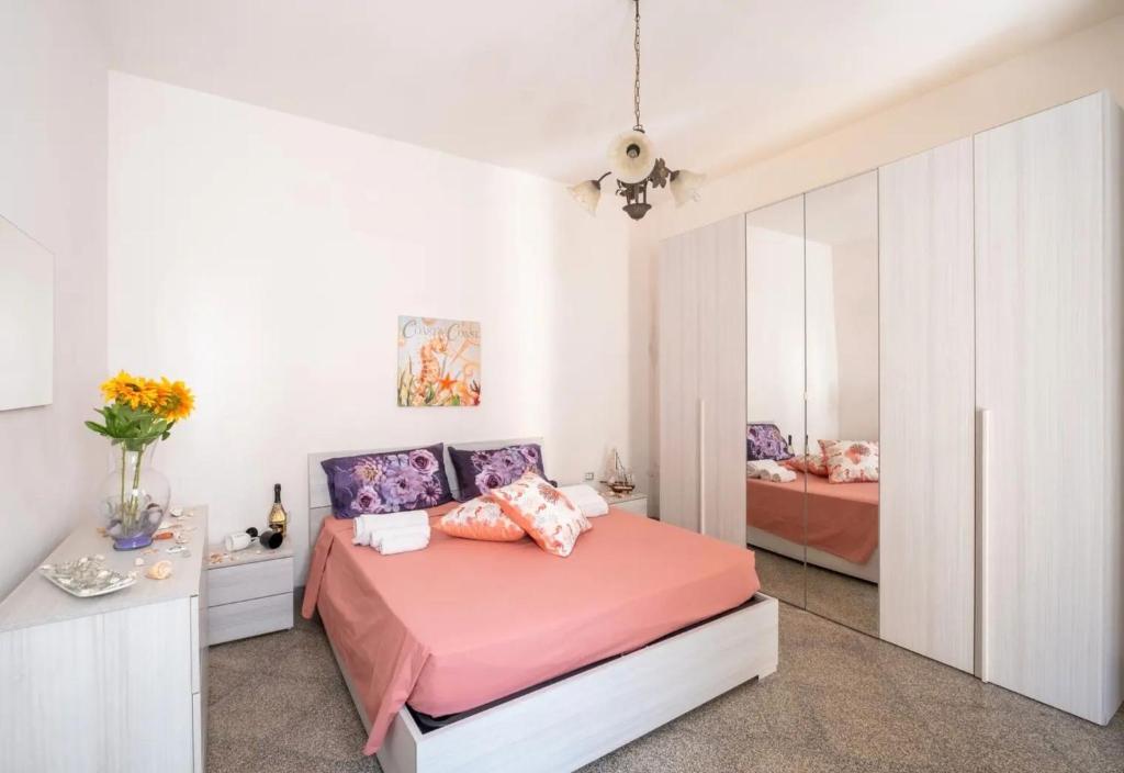 a bedroom with a pink bed and a mirror at Chill e Relax Sul Mare in Sant'Isidoro