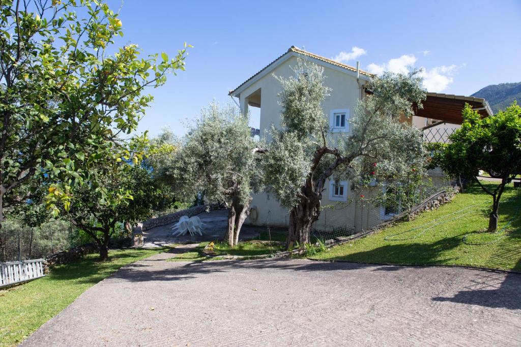 a house with trees in front of a driveway at Ionian Sea in Nikiana