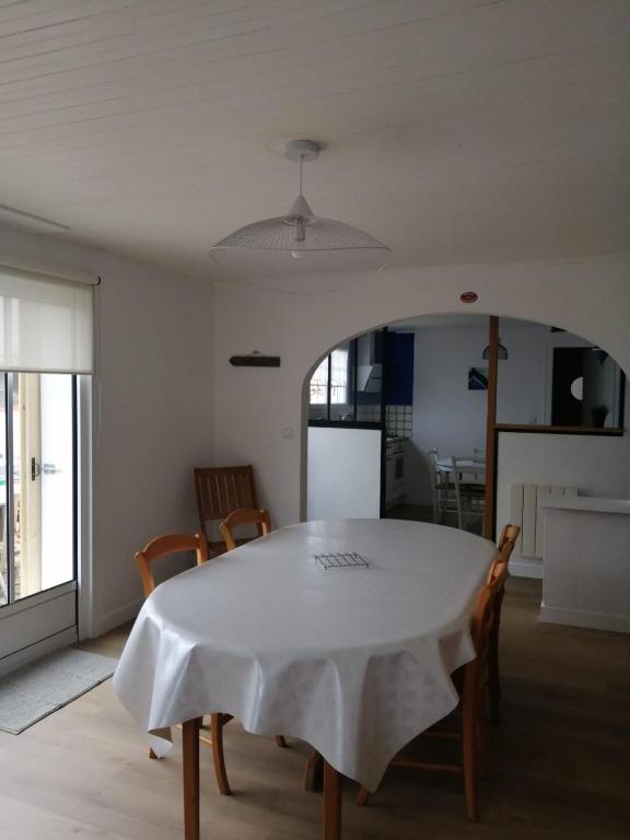 une salle à manger avec une table et des chaises blanches dans l'établissement La tidette, à La Celle-sous-Gouzon