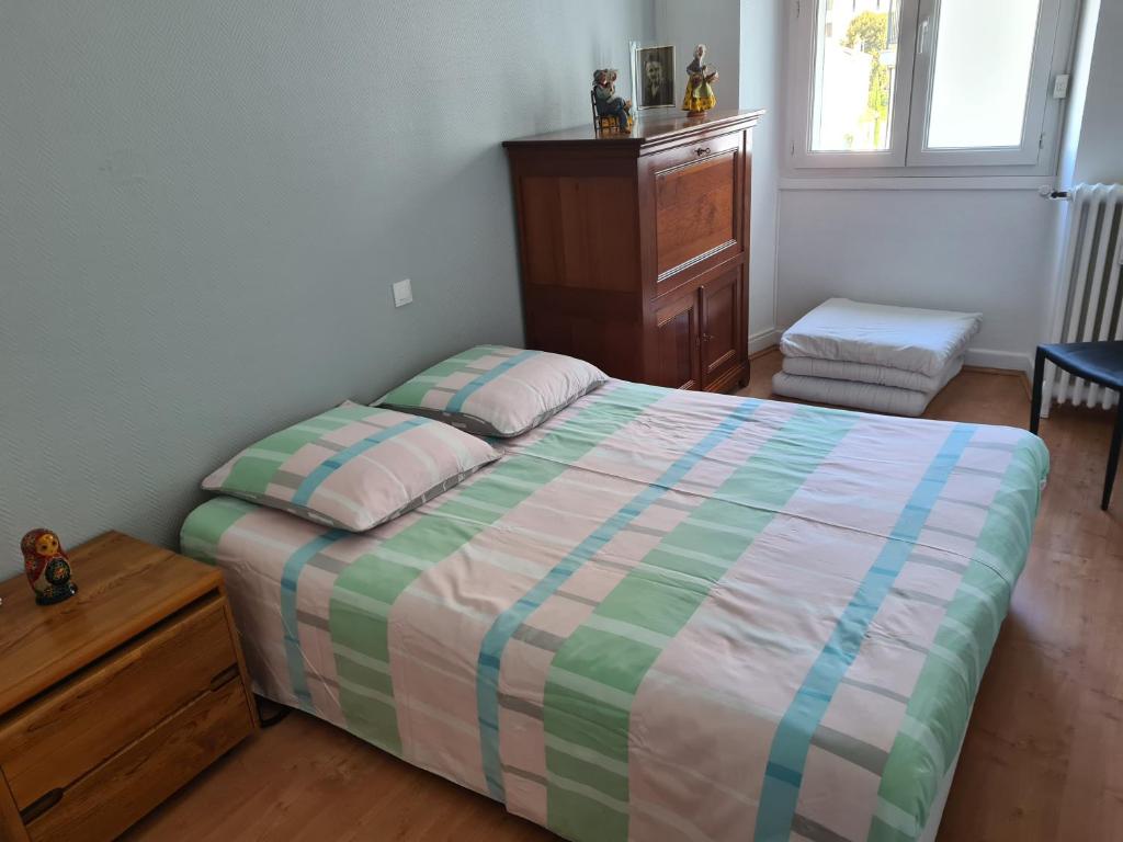 une chambre avec un lit et une commode dans l'établissement Cannes Gallia Centre, à La Celle-sous-Gouzon
