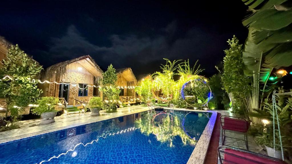 a resort with a swimming pool at night at Hang Múa Lotus Homestay in Ninh Binh