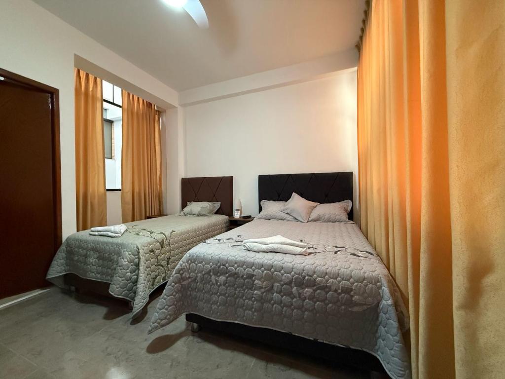 une chambre avec deux lits et une fenêtre dans l'établissement Estancia Luz y Armonía, à Casma