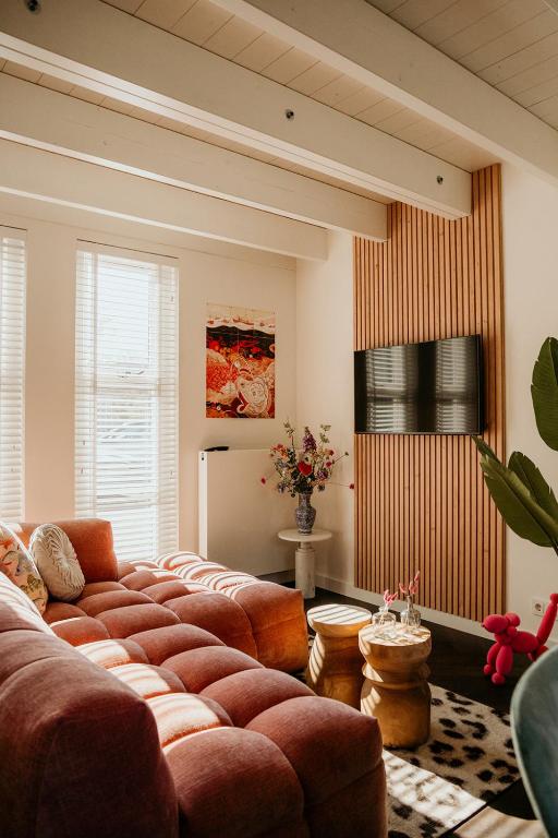 a living room with a large red couch at Slapen aan Zee in Vlissingen