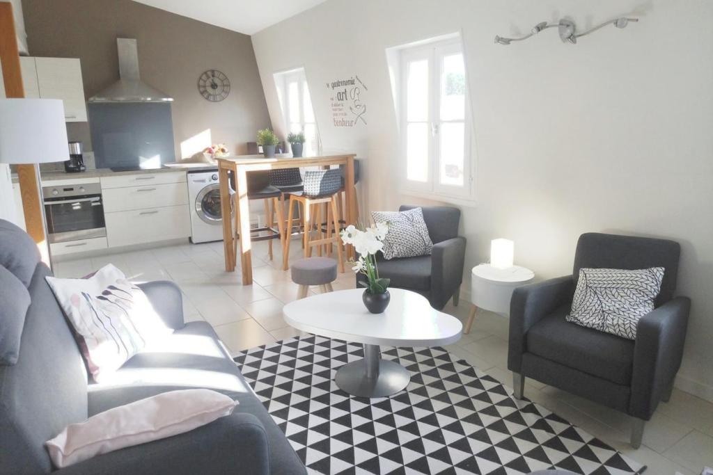 un salon avec un canapé, des chaises et une table dans l'établissement Appartement au cœur de La Rochelle avec parking, à La Rochelle