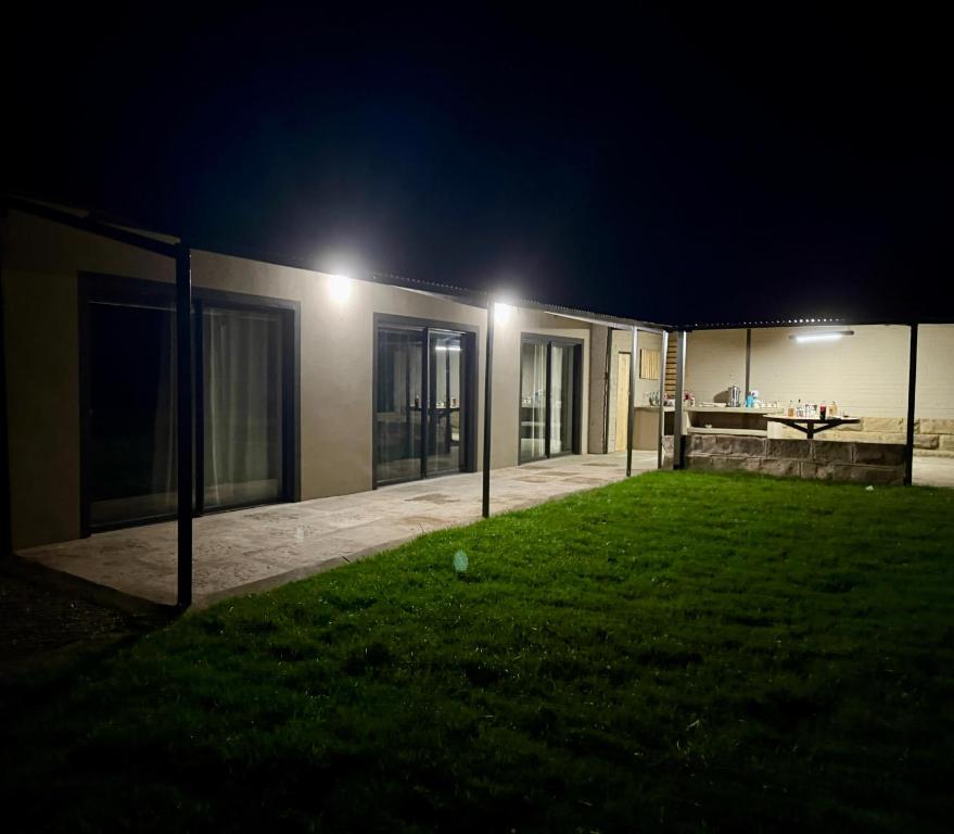 a house with a yard at night with lights at The Mills in Warden