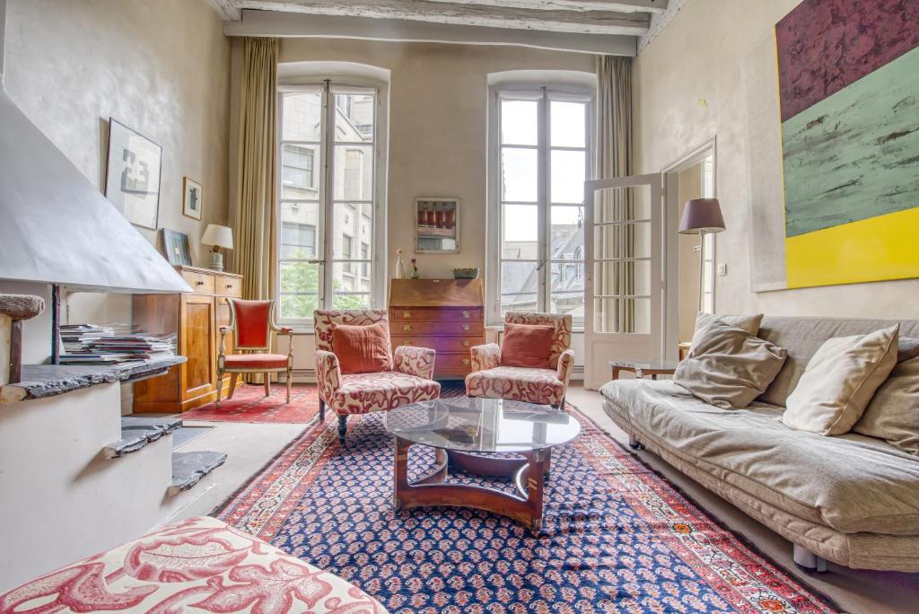 un salon avec un canapé et une table dans l'établissement Aquino, à Paris