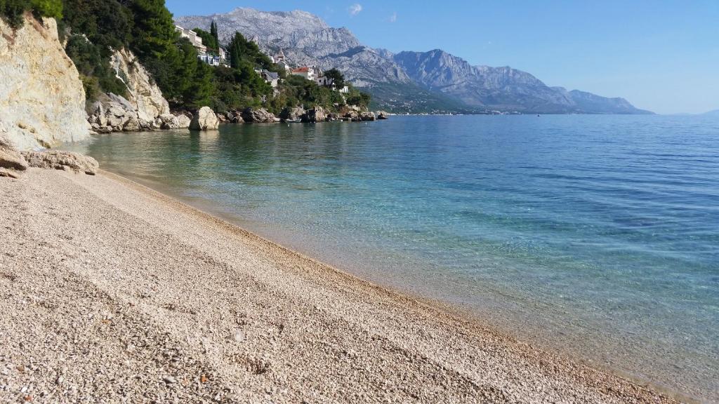 einen Strand mit felsiger Küste und Wasser in der Unterkunft Villa Antonio in Pisak