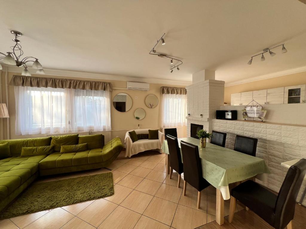 salon z zieloną kanapą i stołem w obiekcie RELAX Apartman w Nyíregyházie