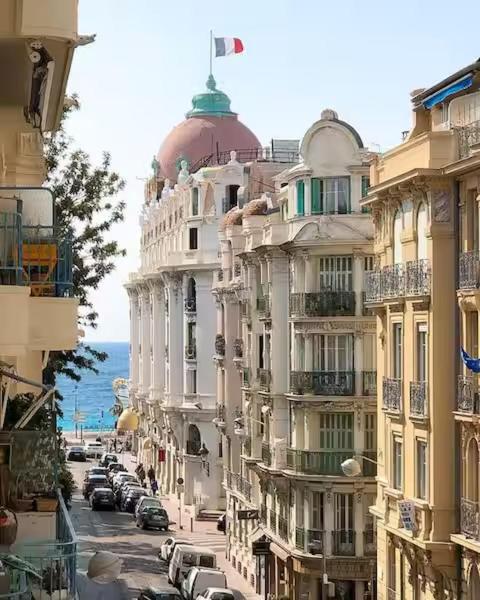 un bâtiment avec un drapeau en haut d'une rue dans l'établissement Superbe appartement, aperçu mer, Negresco-centre, à Nice