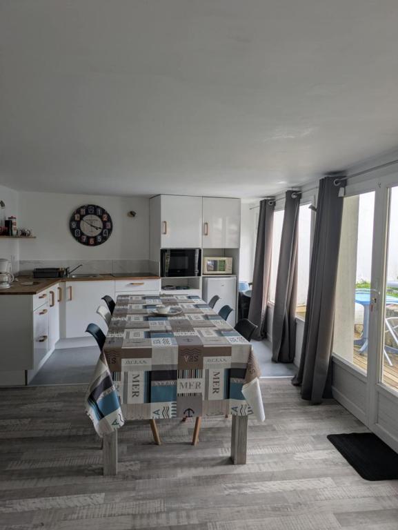 un salon avec une table et une cuisine dans l'établissement Ti Louker - Appartement à 300m du Port, à Locmiquélic