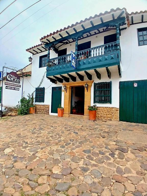 a building with a balcony and a porch at HOTEL El CORZO DE LA VILLA in Villa de Leyva