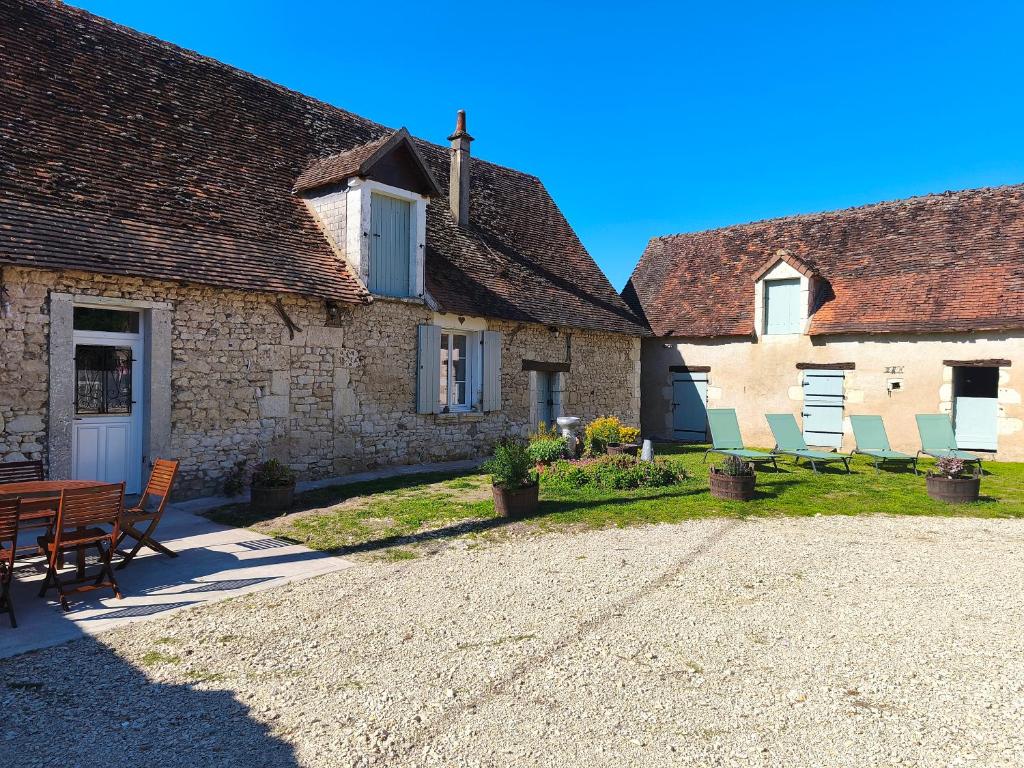 un groupe de maisons avec des chaises et une table dans l'établissement Gîte Chez Renée, à Azay-le-Ferron