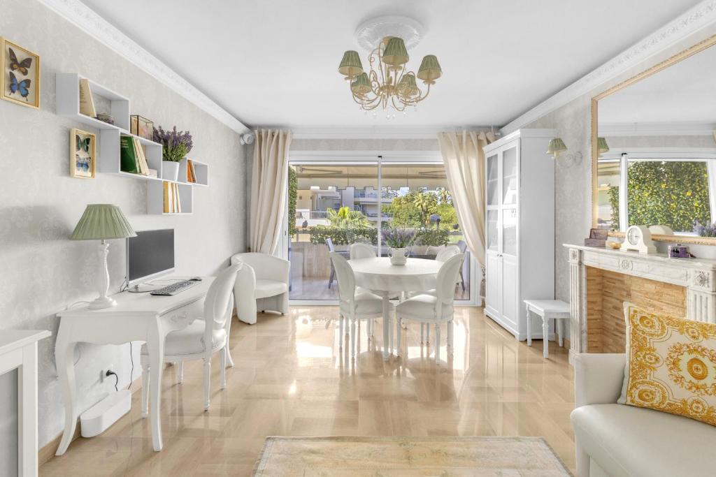 - un salon avec une table, des chaises et un bureau dans l'établissement Appartement CANNES IMPERIAL Pointe Croisette, à Cannes