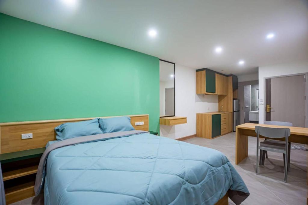 a bedroom with a bed and a desk and a kitchen at Terpenica in Pattaya