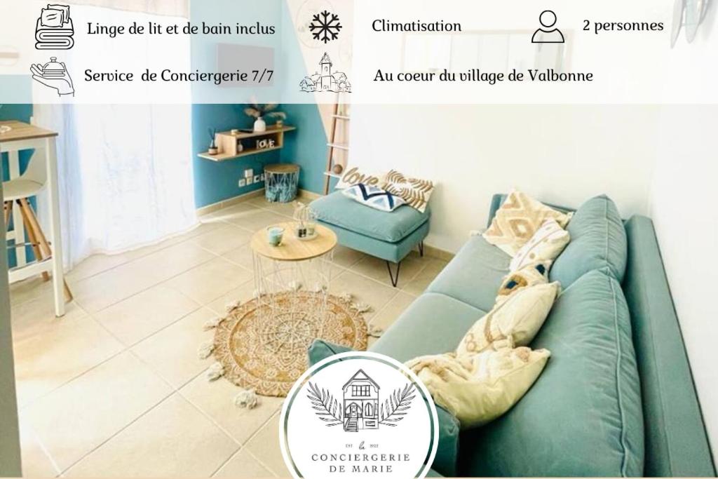 un salon avec un canapé bleu et une table dans l'établissement Studio cosy et climatisé au coeur du village, à Valbonne