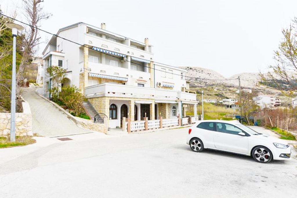 a white car parked in front of a building at Apartments Galinec in Metajna