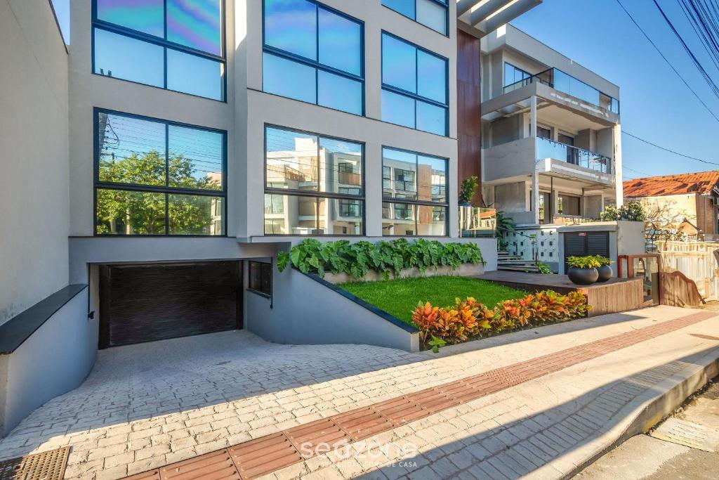 a large white building with a courtyard in front of it at Sua estadia próxima da Praia Brava - BSO in Cabeçudas