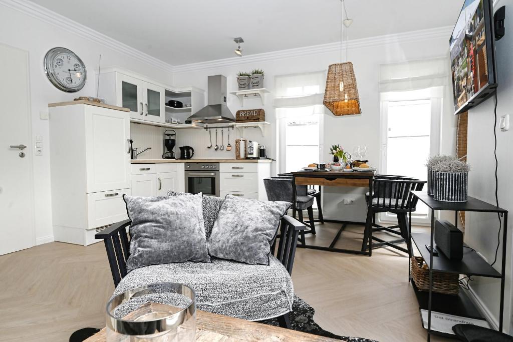 un soggiorno e una cucina con un divano e un tavolo di Dat Strandhus Apartment 1 a Büsum