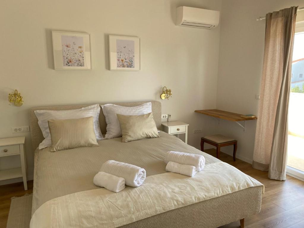 a bedroom with a large bed with two pillows on it at Villa Botanica in Bale