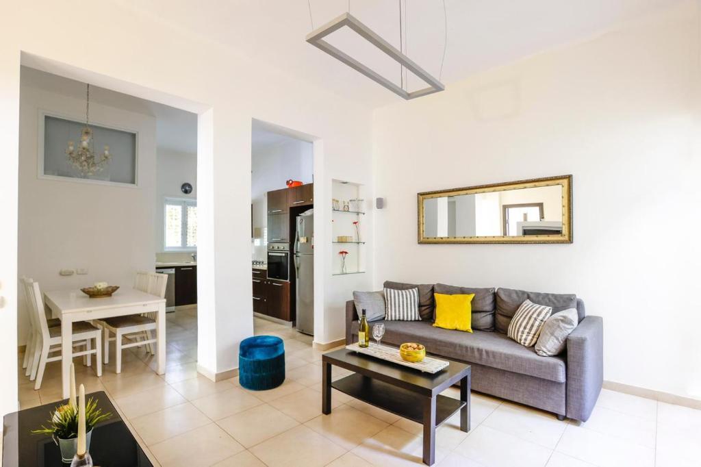 una sala de estar con un sofá y una mesa en Spacious 2BR Apartment with 2 Bathrooms, Living Room & Kitchen - Prime LocationNear ddizengoff st, en Tel Aviv