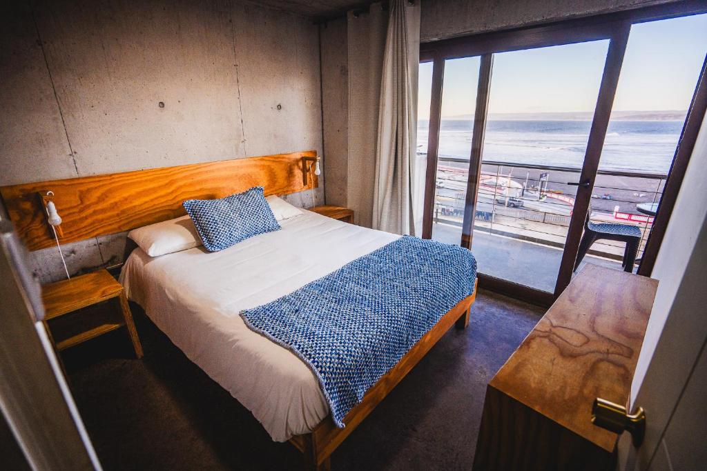 una camera da letto con un letto e vista sull'oceano di Apart Hotel Kudun a Pichilemu