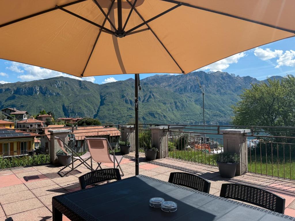 un patio con una mesa y una sombrilla en Cà Ventanas Bellagio, en Bellagio