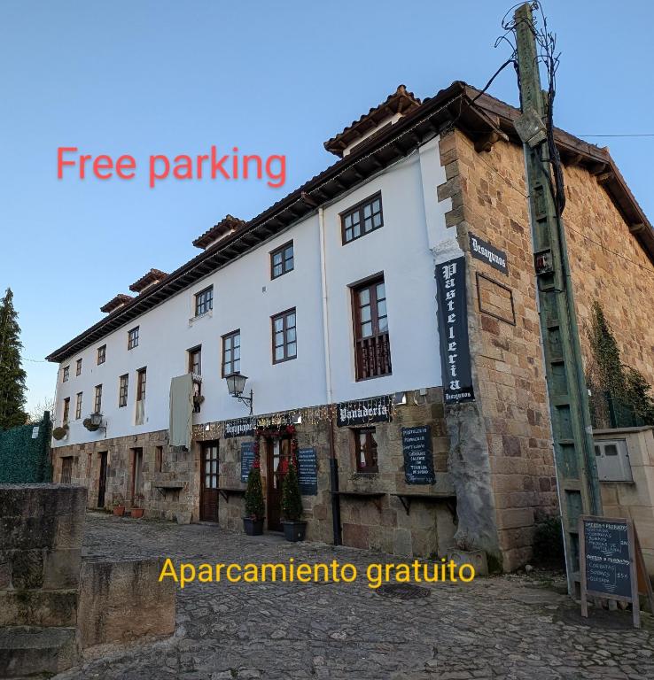 a building with a sign on the side of it at Casa Fita con Parking in Santillana del Mar