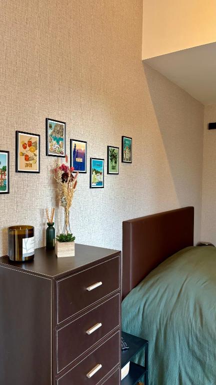 - une chambre avec un lit, une commode et des photos sur le mur dans l'établissement Studio Prenois, à Prenois