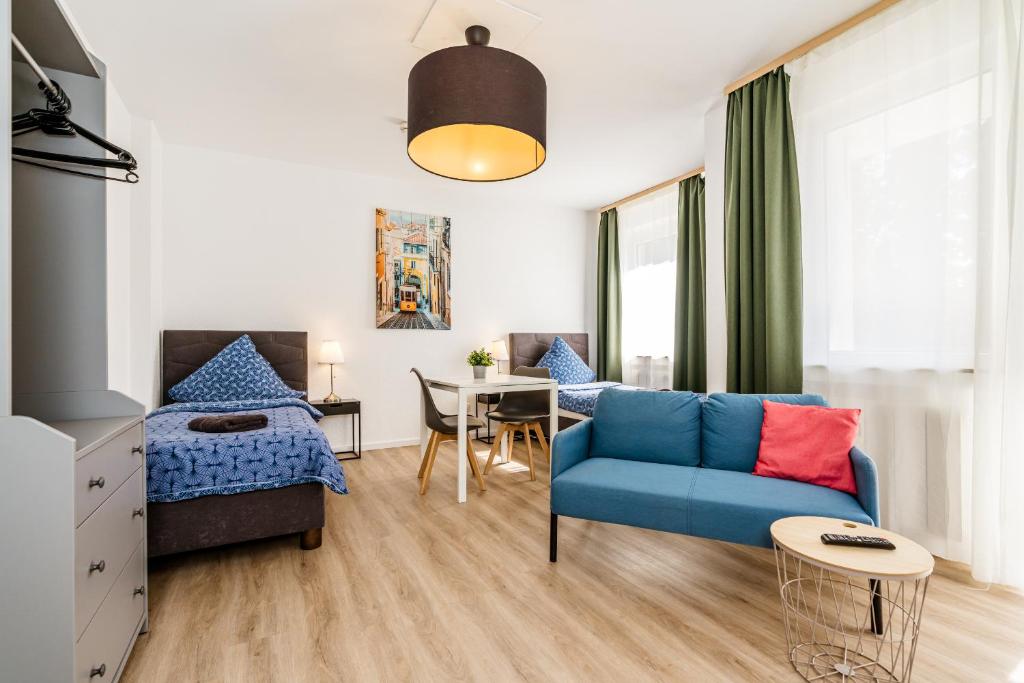 a living room with a blue couch and a table at Centerline Apartments Solingen in Solingen