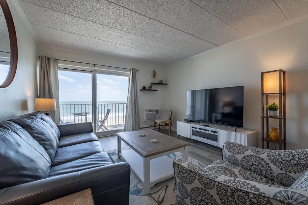 a living room with a couch and a flat screen tv at Barefoot Country 404 - Serenity Now in Ocean City