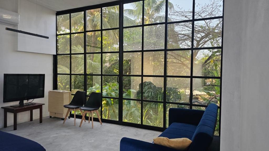 a living room with a blue couch and a large window at casaroja in Palenque