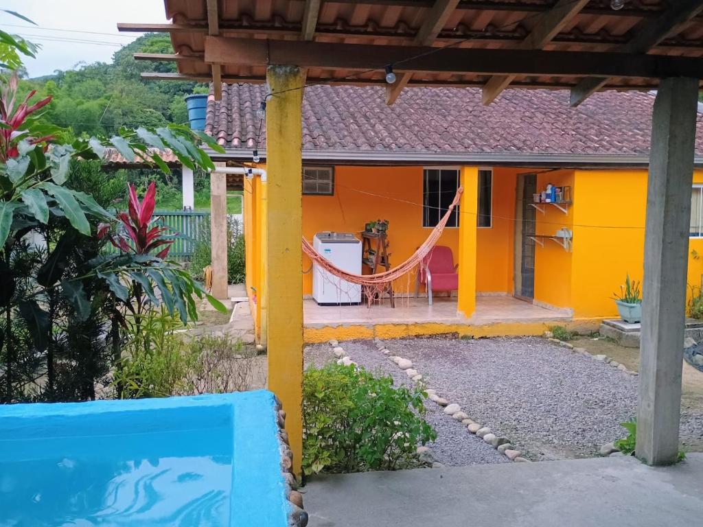 a house with a hammock in front of it at Casa da Flor in Morretes
