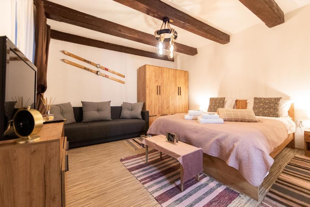 a bedroom with a large bed and a couch at Saint Marco35th in Braşov