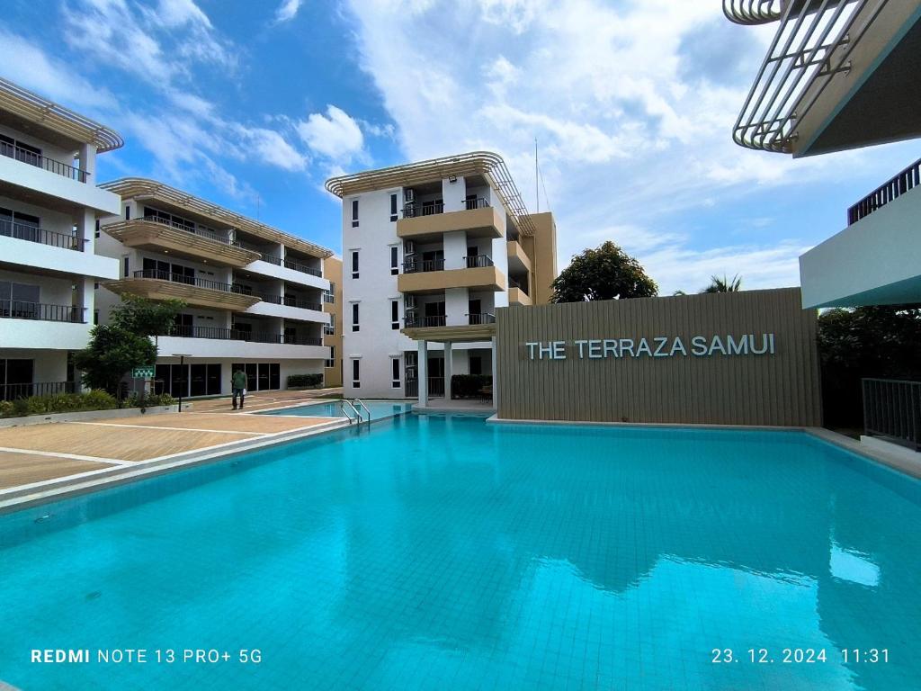a large swimming pool in front of a building at Modern Apartment with Queen Bed in Living Room & Separate Bedroom in Lamai