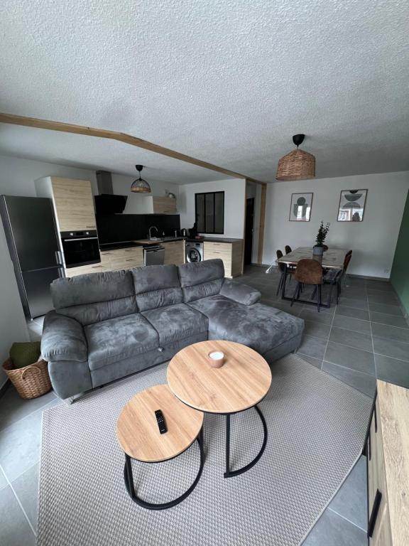 a living room with a couch and a table at Spacieux et confortable - centre ville de BRIANCON - SERRE-CHEVALIER - Garage et Wifi in Briançon
