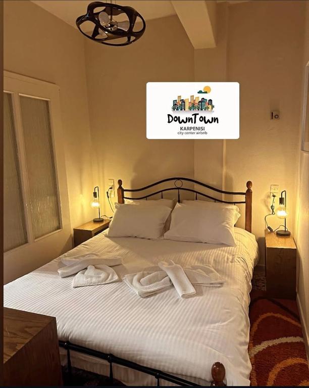a bedroom with a bed with two towels on it at Down Town Karpenhsi in Karpenisi