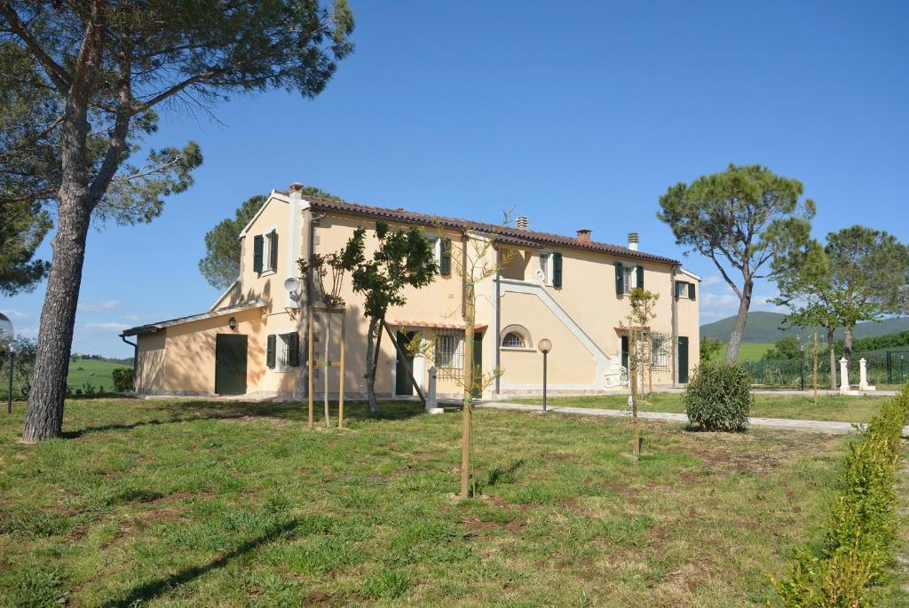 una vecchia casa con alberi di fronte di Agriturismo Dei Setteventi a Santa Luce