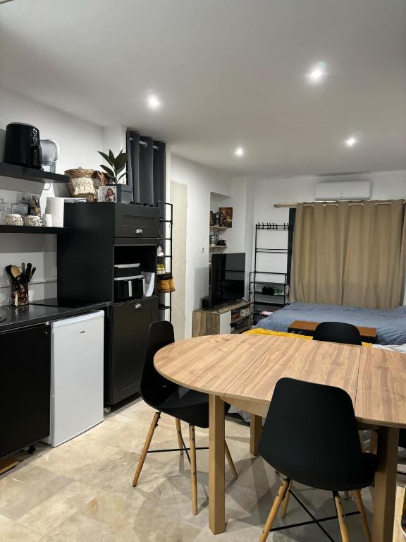 une pièce avec une table, des chaises et un lit dans l'établissement Studio avec accès piscine, à Nîmes