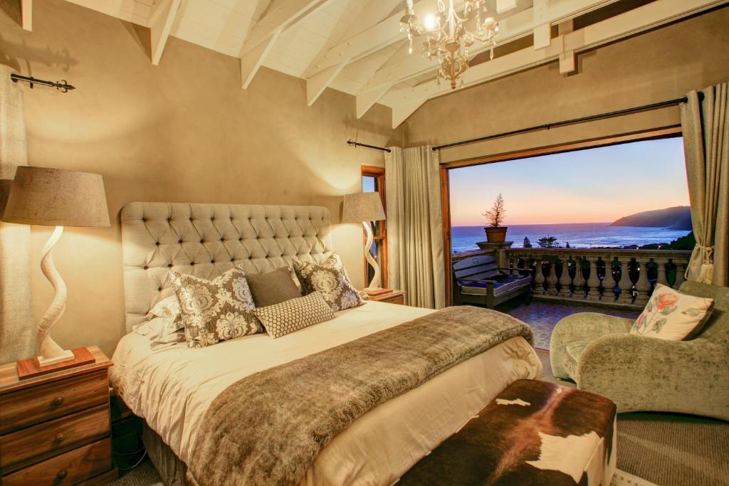 a bedroom with a bed and a large window at Livingstone Villa in Wilderness