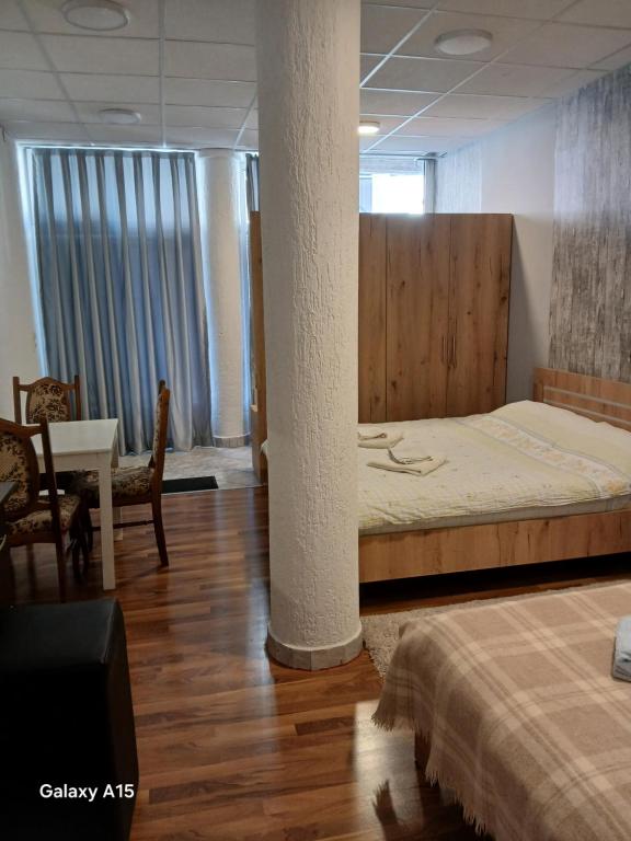 a bedroom with a bed and a table and chairs at Eni Rooms in Ohrid