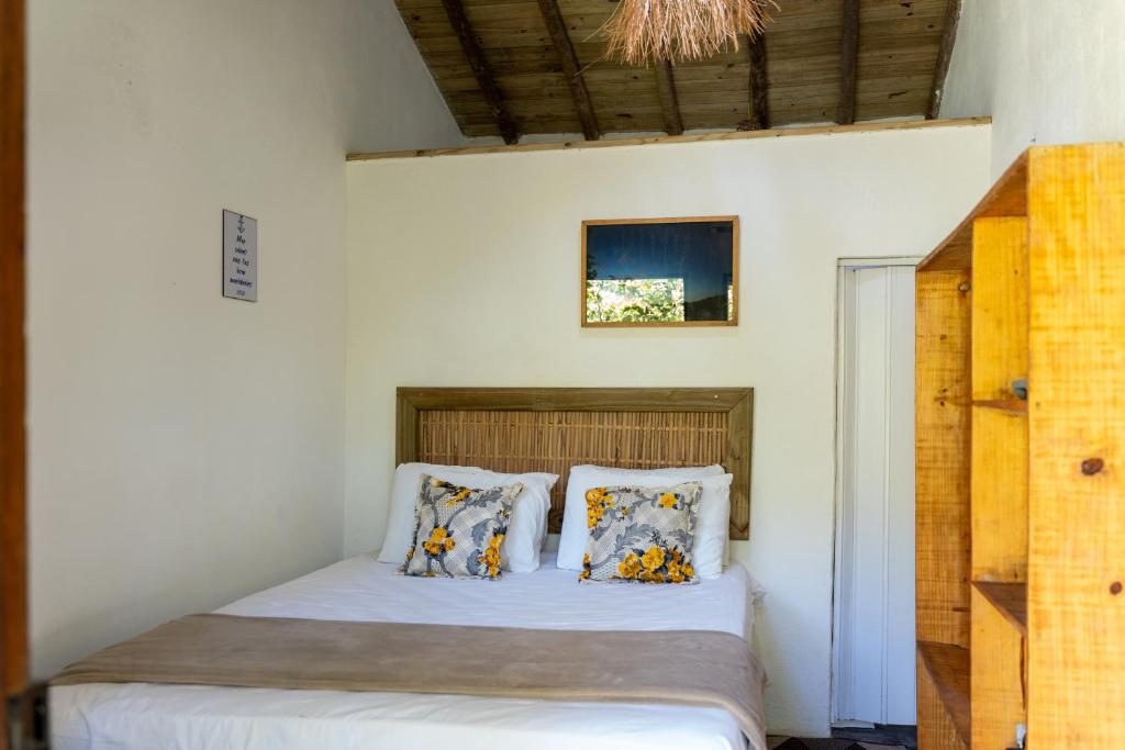 a bedroom with a bed with white sheets and pillows at Vila Bijupirá in Caraíva