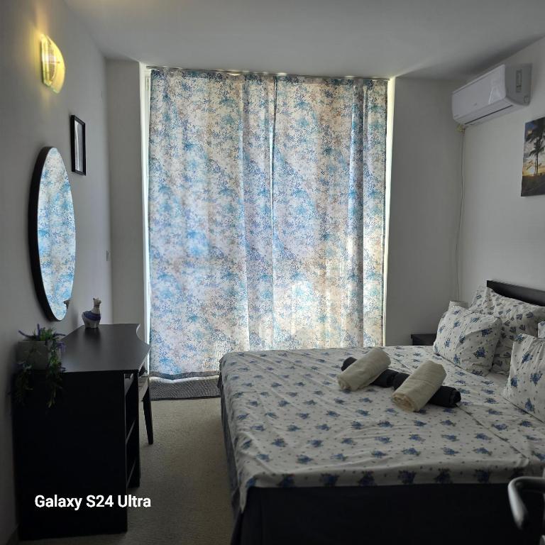a bedroom with a bed and a large window at Apartament Primavera Atlantis SPA in Burgas