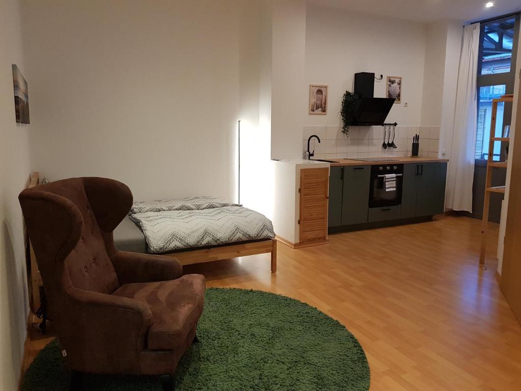 un salon avec une chaise et une table dans l'établissement Apartment Ferienglück - Zentraler Rückzugsort, à Neuruppin